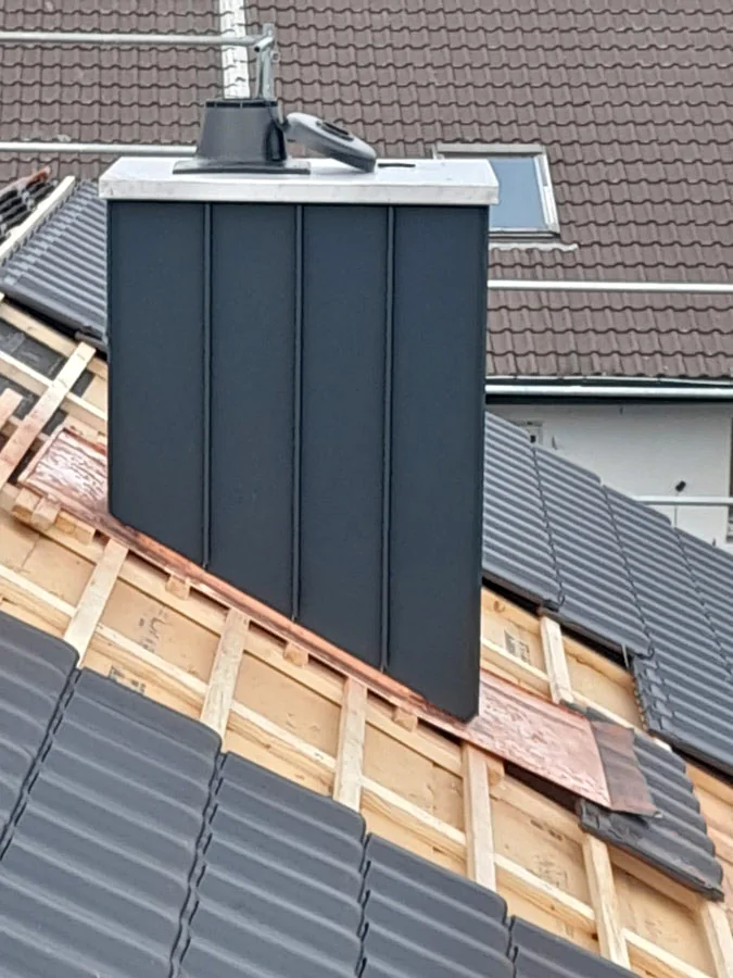 Neu verkleideter Kamin auf einem Steildach